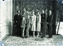Alfonso XIII posando con sus hijos dispuestos por orden de nacimiento con tapiz como telón de fondo