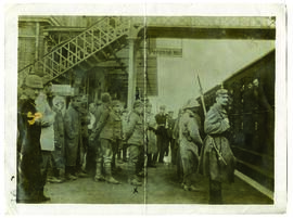 El soldado T. Hands entre los prisioneros que esperan subir al tren desde el anden de la estación...